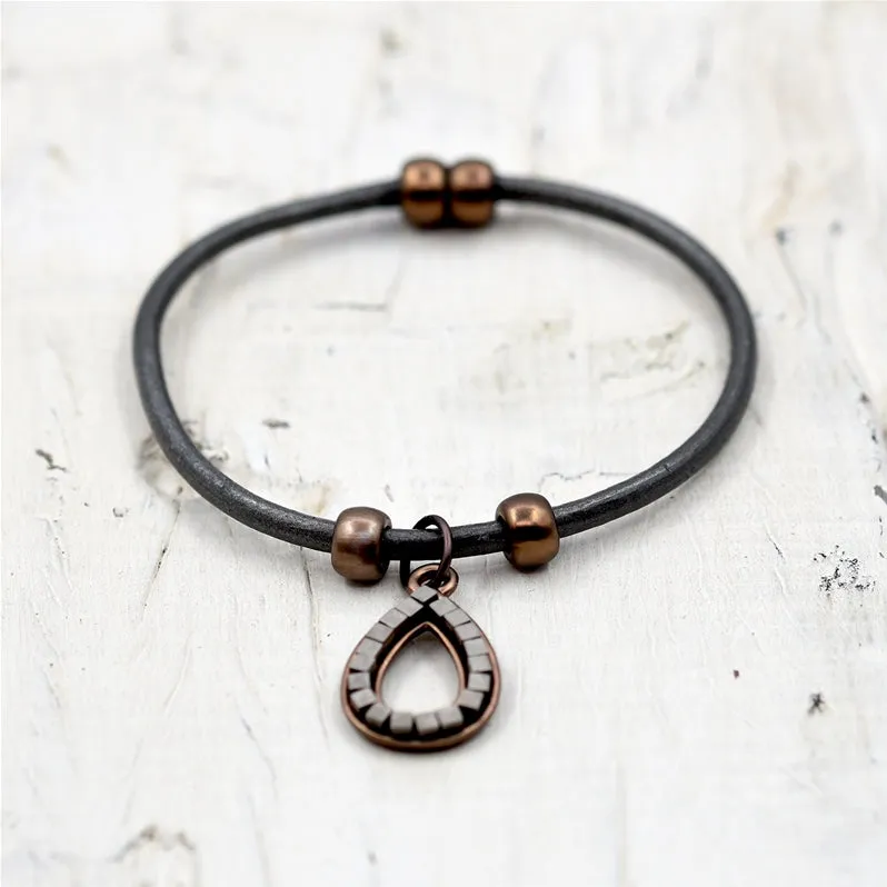 Cutout teardrop pendant with little squares on leather brace
